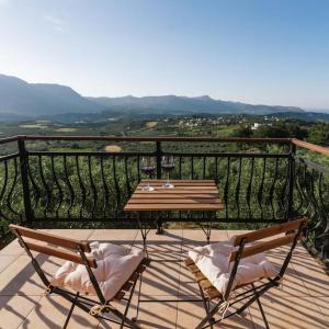- Balcón con mesa de madera y 2 sillas en Myron Olive Villa Retreat en Áyios Míron
