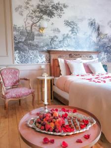 a room with two beds and a tray of fruit on a table at Domaine Le Clos de la Source - Petit déjeuner buffet in Montrichard