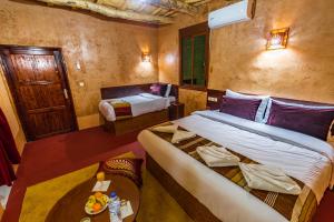 Zimmer mit 2 Betten und einem Tisch in der Unterkunft Palais Ksar Lamane in Aït-Ben-Haddou