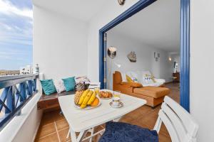 sala de estar con mesa y sillas en el balcón en Home2Book Charming Apt Caleta de Caballo Beach, en Caleta de Caballo