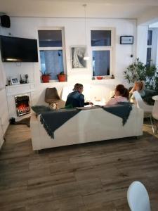 a group of people sitting at a table in a living room at Tina Guest House in Basarabi