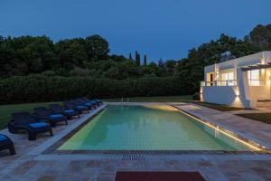 カシオピにあるVilla Rosemarineの家の隣にある椅子付きのスイミングプール