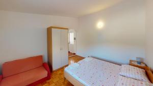 a bedroom with a bed and a couch in it at Jaska & Jelica House apartments in Metajna