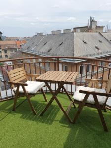 a picnic table and two chairs on a roof at Modern top floor loft with balcony in Budapest