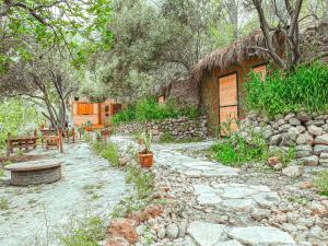 a painting of a house with a stone path and a building at Hobbit village in Dana