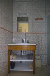 ein Bad mit einem Waschbecken und einem Spiegel in der Unterkunft LE BIGARADIER in Sainte-Rose