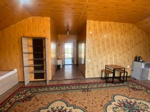 a room with wooden walls and a table and a rug at Eram Garden Hotel in Bosteri