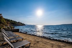 eine Reihe von Chaiselongues am Strand in der Unterkunft İsolina Bodrum in Bodrum City