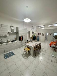 una cucina con tavolo e sedie in una stanza di Monte Rosa Apartments a Torre San Giovanni Ugento