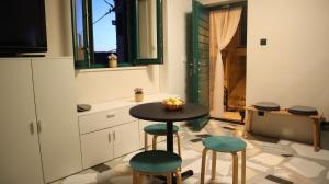 a small kitchen with a table and two stools at Apartment Lemon in Šibenik