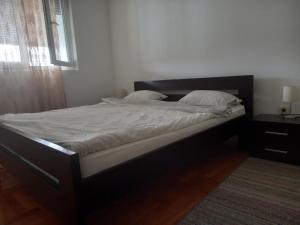 ポドゴリツァにあるFantastic brand new apartment 2の寝室にある白いシーツと枕が置かれたベッド