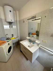 bagno con lavandino e lavatrice di Monte Rosa Apartments a Torre San Giovanni Ugento