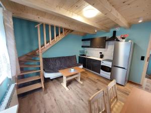 kuchnia i jadalnia z łóżkiem na podwyższeniu w małym domku w obiekcie Domek pod soszowem w Wiśle