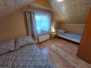sypialnia z 2 łóżkami i oknem w obiekcie Domek pod soszowem w Wiśle