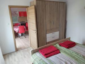 ein Schlafzimmer mit einem Bett mit zwei roten Handtüchern darauf in der Unterkunft APARTMENTS KRAPEC3 in Ježdovec