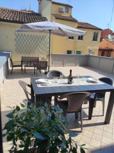 - une table et des chaises avec une bouteille de vin et un parasol dans l'établissement Casa Crispi, à Chioggia