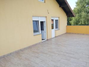 a patio in front of a yellow house at APARTMENTS KRAPEC3 in Ježdovec