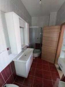 a bathroom with a sink and a shower and a toilet at APARTMENTS KRAPEC3 in Ježdovec