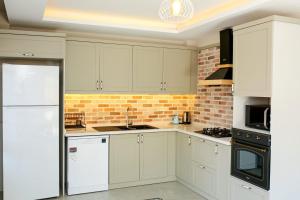 a kitchen with white cabinets and a brick wall at Dalyan Central 4 Bedroom Ensuite Private Villa with Swimming Pool in Dalyan