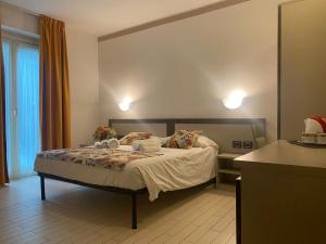 a bedroom with a bed and a table with a cake on it at Hotel Lago di Como in Colico