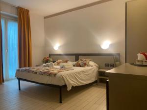 コーリコにあるHotel Lago di Comoのベッドルーム1室(ケーキ付きのテーブル、ベッド1台付)