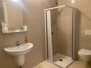 een badkamer met een douche, een wastafel en een toilet bij Hotel Lago di Como in Colico