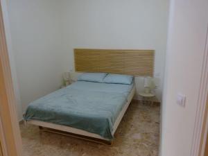 Apartamento La Fuente Alcaucin في ألكاوثين: غرفة نوم صغيرة مع سرير مع نافذة