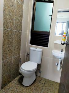 a bathroom with a toilet and a sink and a window at TOP Muzaffar Homestay in Ayer Keroh