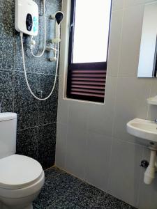 a bathroom with a toilet and a sink at TOP Muzaffar Homestay in Ayer Keroh
