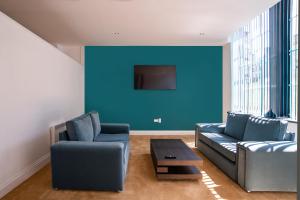 sala de estar con sofá y pared azul en The Castle Collection - 5 Union Court en Liverpool