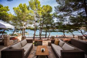 a patio with furniture and a view of the water at Labranda Senses Resort in Vrboska