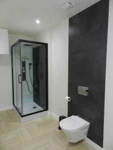 a bathroom with a glass shower and a toilet at HOTEL MANEL in Martorell