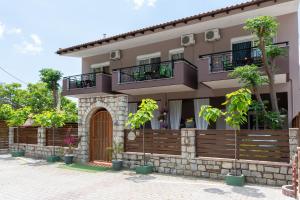 a house with two balconies on top of it at Studios Diogenis in Porto Koufo