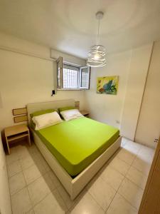 una camera con letto verde e finestra di Monte Rosa Apartments a Torre San Giovanni Ugento