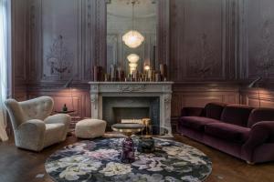 a living room with a fireplace and a couch and a table at Yndo Hôtel in Bordeaux