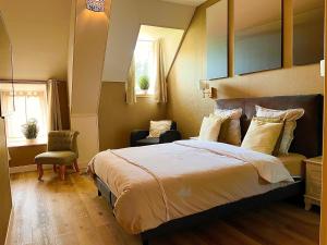 una camera con un grande letto e una finestra di Le Manoir des Haies a Les Champs-Géraux
