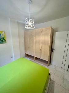 トッレ・サン・ジョヴァンニ・ウジェントにあるMonte Rosa Apartmentsの木製のキャビネットが備わる緑の床の客室です。