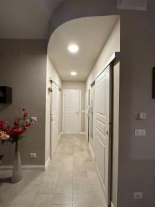 um corredor com portas brancas e um vaso de flores em A casa di Rosy em Casalecchio di Reno