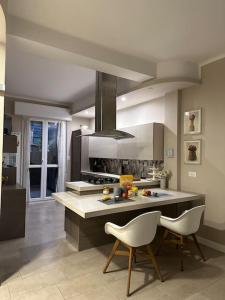 uma cozinha com 2 cadeiras brancas e um fogão em A casa di Rosy em Casalecchio di Reno