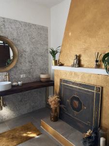 a bathroom with a fireplace with a sink and a mirror at Casal Camillo in Case Selva Grande