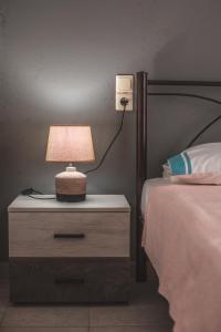 a lamp on a night stand next to a bed at Pelion Charming Cottage, Panoramic Seaview Retreat in Volos