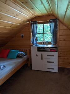 sypialnia z łóżkiem i oknem w kabinie w obiekcie Góralski domek w Kluszkowcach w Kluszkowcach