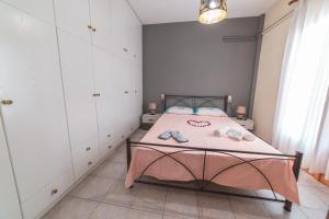 a bedroom with a bed with a pink blanket at Pelion Charming Cottage, Panoramic Seaview Retreat in Volos