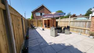 eine Terrasse mit einem Sonnenschirm und einem Zaun in der Unterkunft The Barbers in Beverley