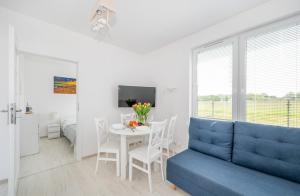Una sala de estar con un sofá azul y una mesa. en Niebiańska Przystań Rusinowo, en Rusinowo