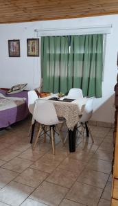 a dining room with a table and chairs and a bed at Departamento monoambiente vacacional in Posadas