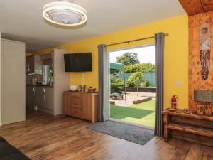 a kitchen with a sliding glass door to a yard at Foxes Den in Ferndown
