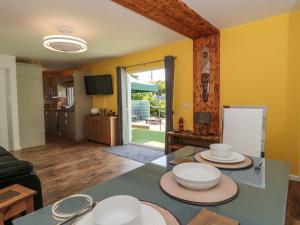 a living room with a table with plates on it at Foxes Den in Ferndown