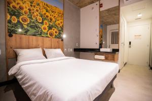 um quarto com uma cama grande e um quadro de girassóis em CAMPOS DE HOLAMBRA INN em Paranapanema