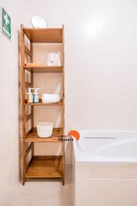 a bathroom with a wooden shelf next to a bath tub at #055 São José V by Home Holidays in Branqueira
